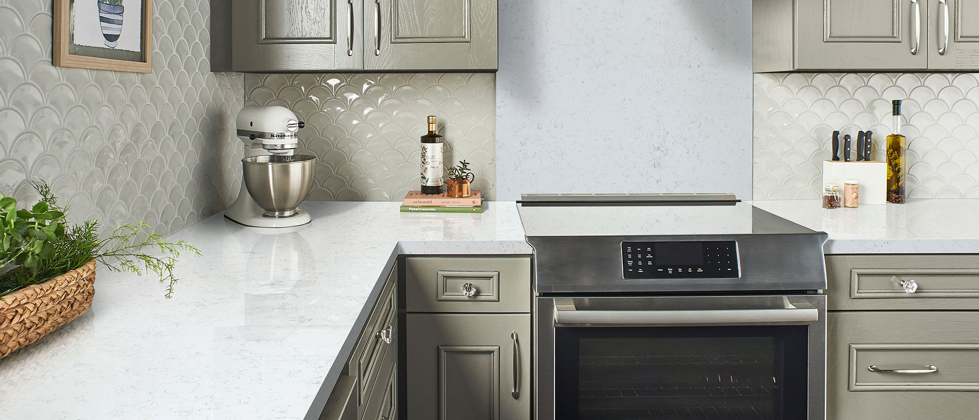 White quartz countertops with gray kitchen cabinets and tile backsplash